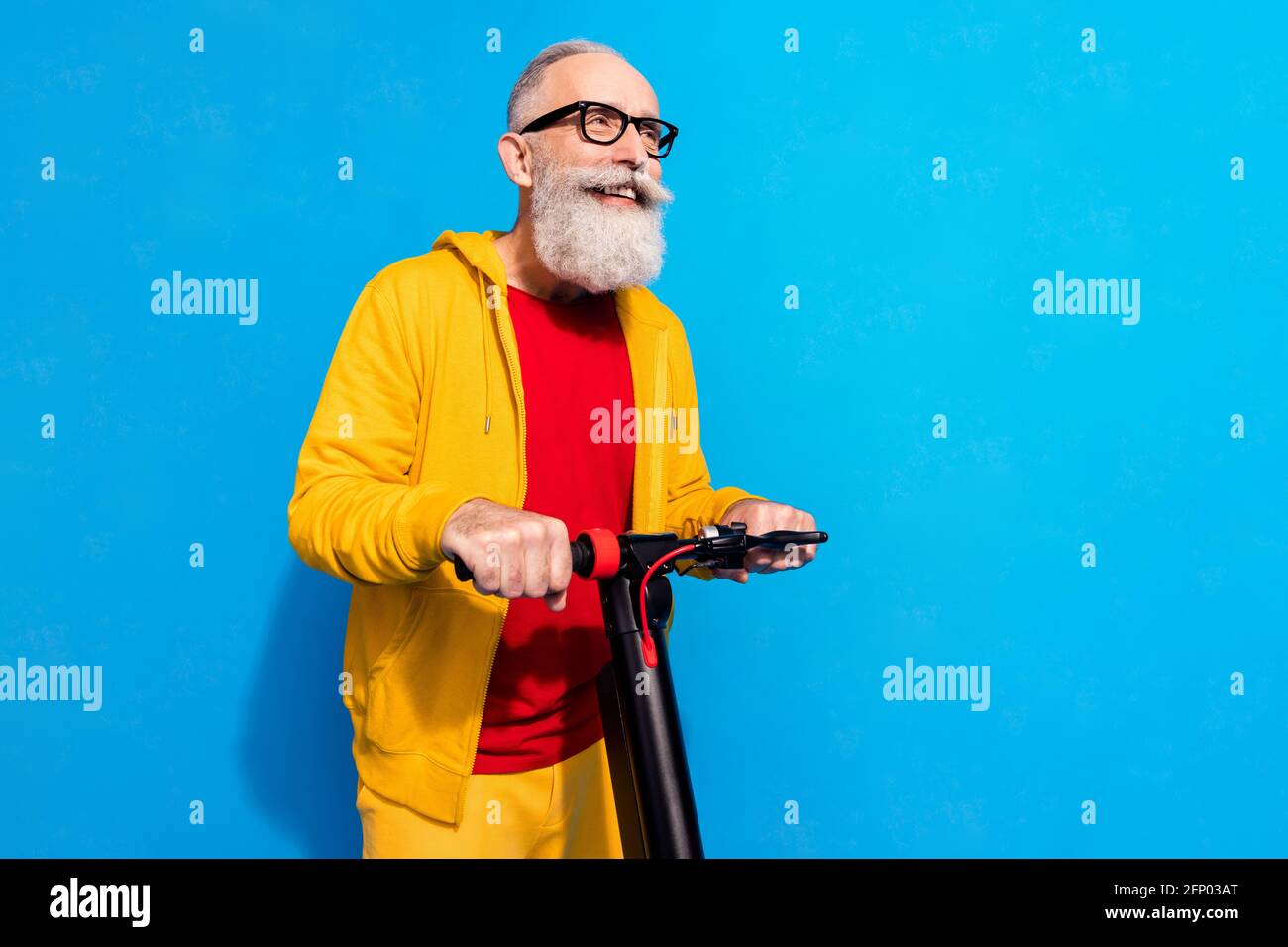 Profile portrait of cheerful aged man driving moped look empty space  isolated on blue color background Stock Photo - Alamy