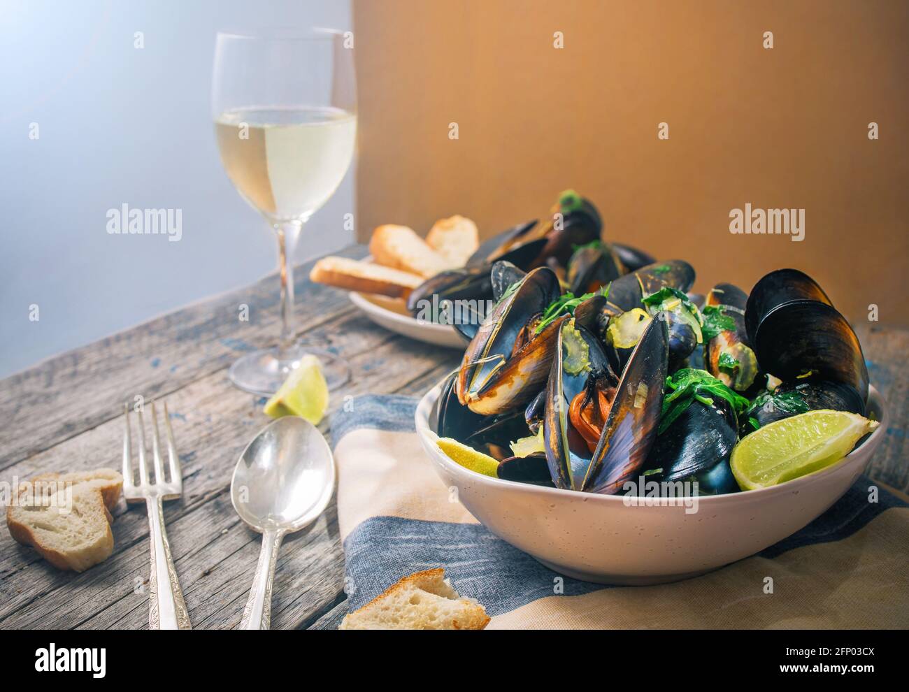 Blue mussles with vine and baguette on wooden table Stock Photo