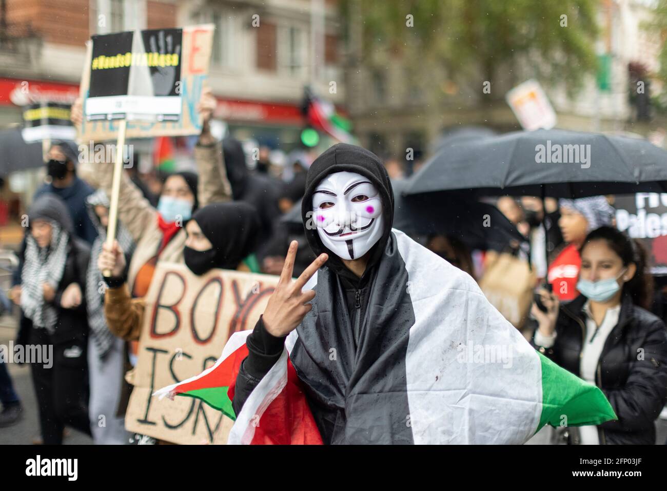 Protester marching in Guy Fawkes mask, 'Free Palestine' solidarity