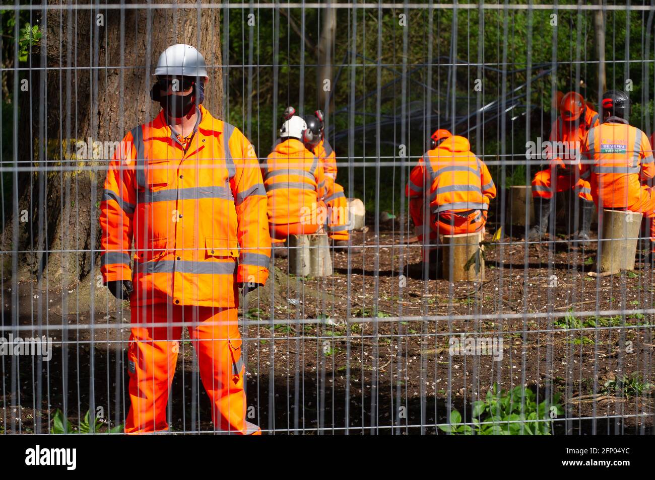Aylesbury, Buckinghamshire, UK. 19th May, 2021. HS2 tree fellers sit on tree stumps felled by them. Local residents and Stop HS2 campaigners were peacefully protesting in Aylesbury today against the High Speed 2 rail which is causing a huge amount of destruction throughout Buckinghamshire. Credit: Maureen McLean/Alamy Stock Photo