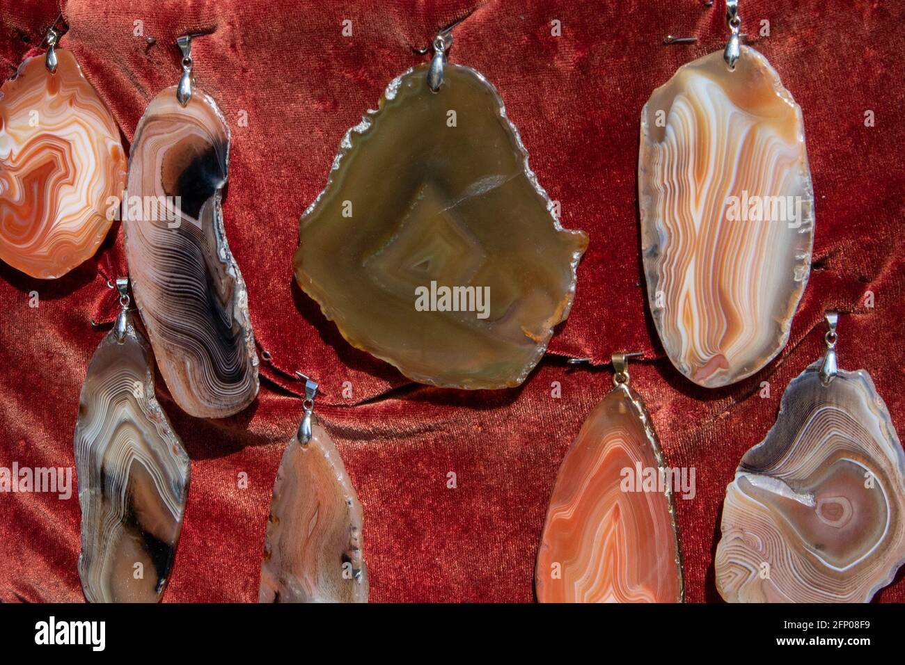 Few different beautiful flat polished agate pendants at the open air fair Stock Photo