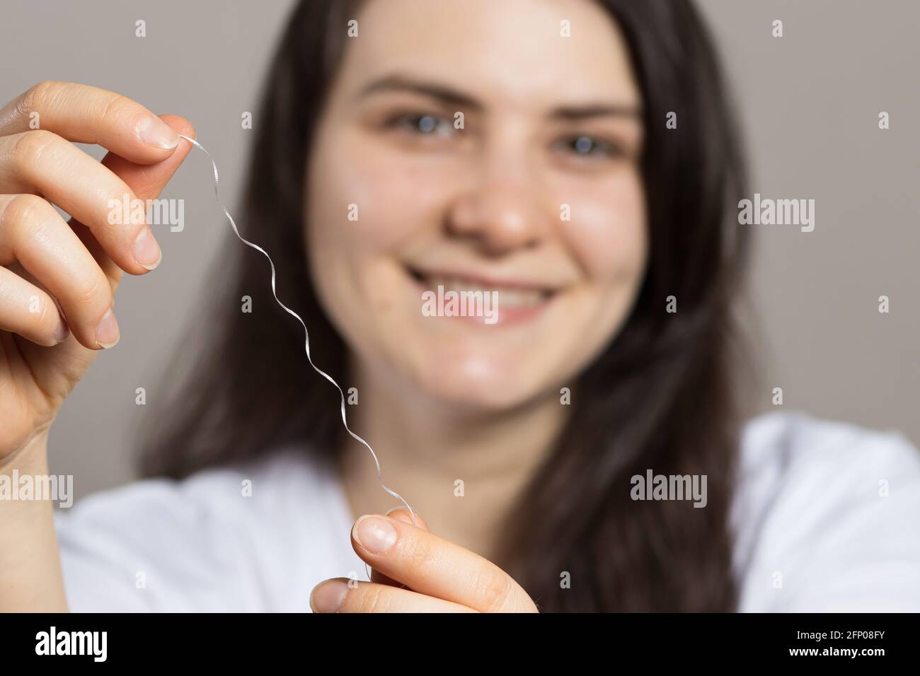 A woman brushes her teeth with flossing. Oral hygiene, plaque