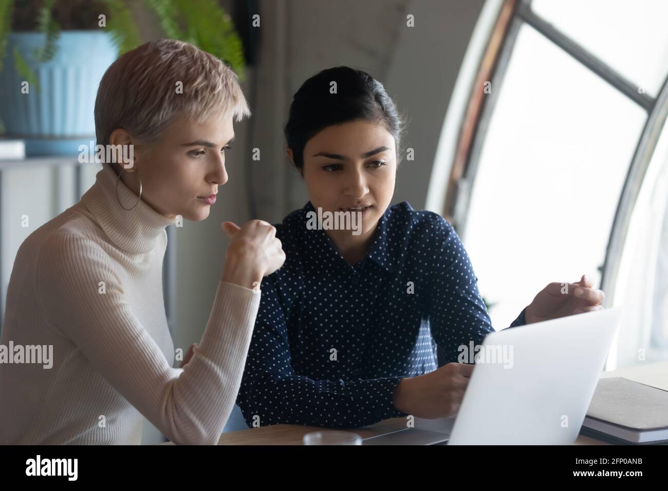 Multiracial female employees brainstorm on laptop in office Stock Photo ...