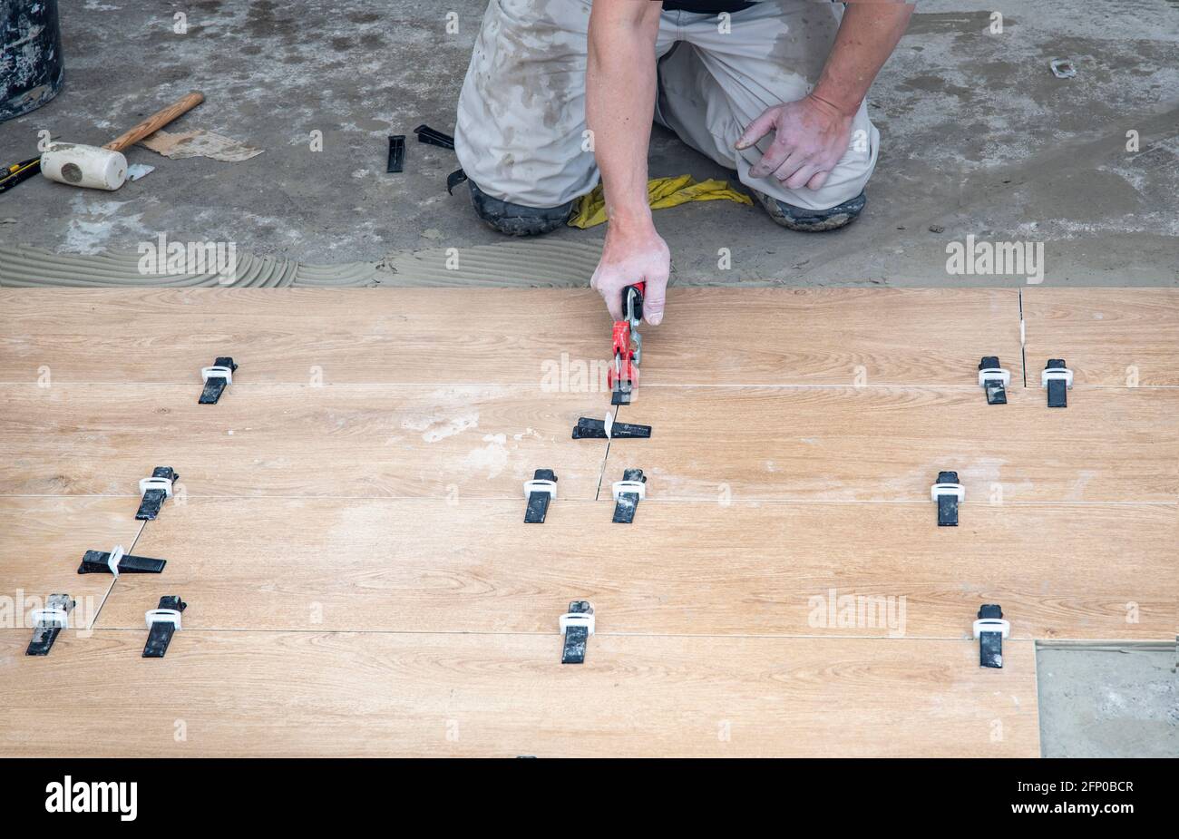 Tiler Lays ceramic tiles on the floor. Tile Leveling Wedges, tile