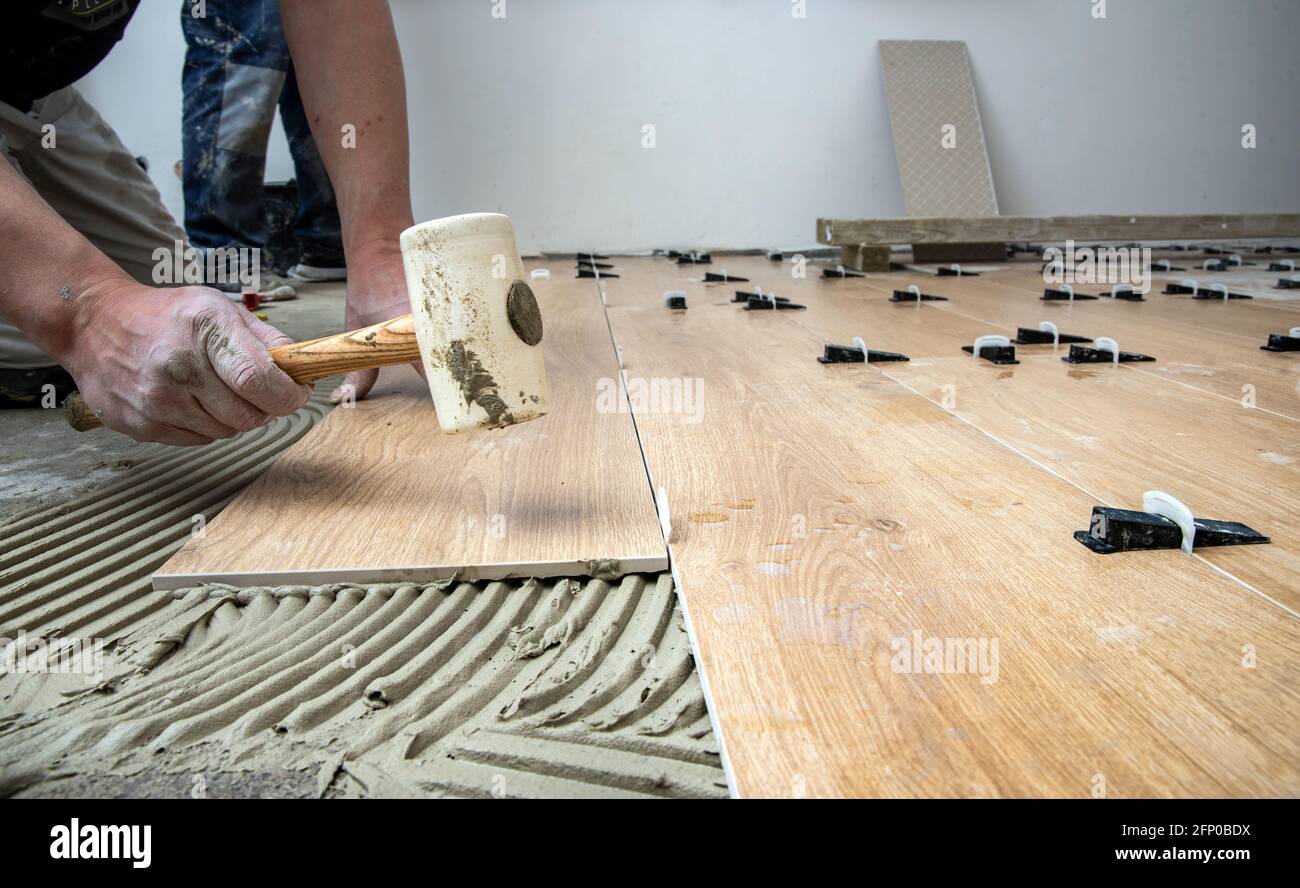 Tiler Lays ceramic tiles on the floor. Tile Leveling Wedges, tile