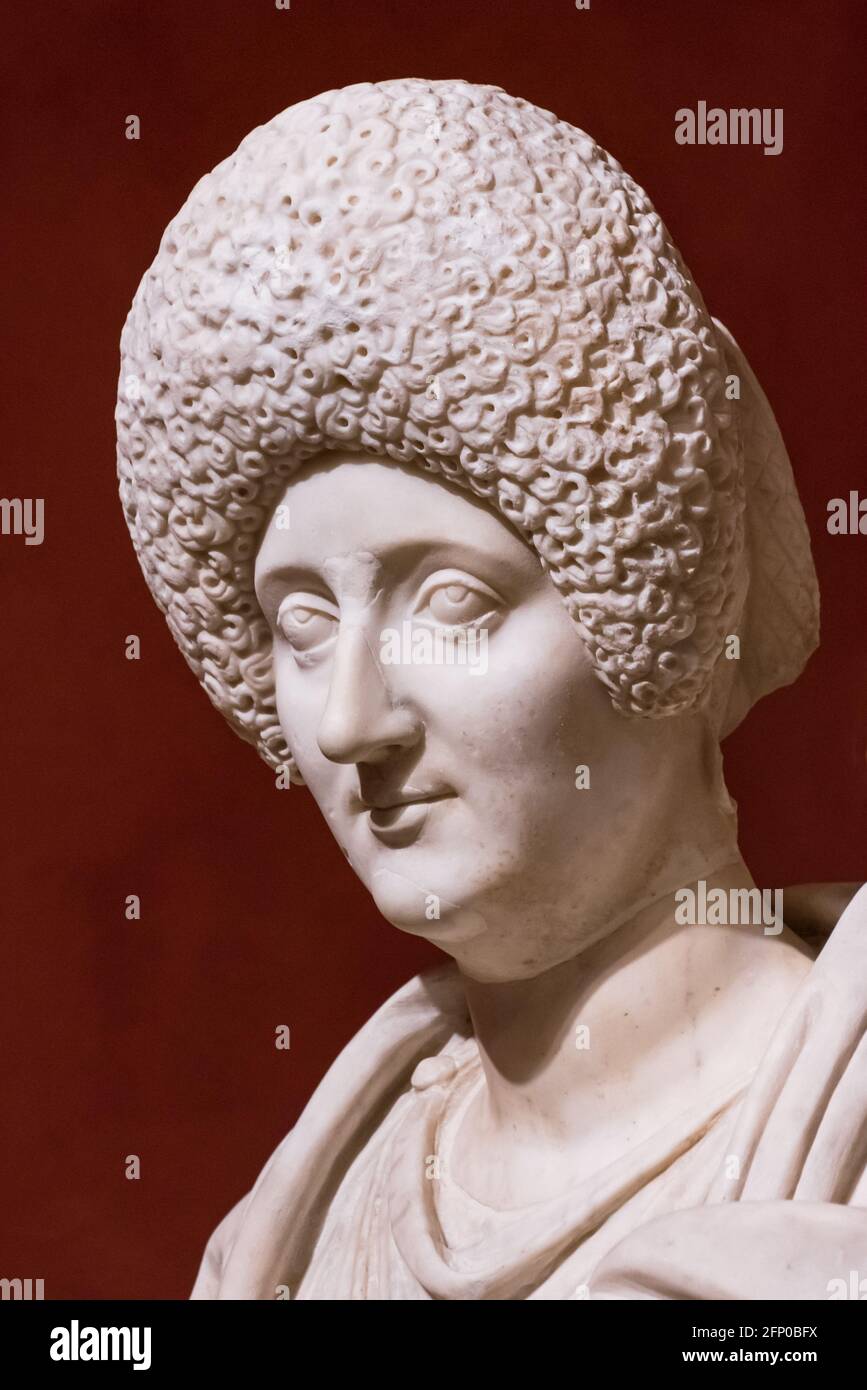 Close-up on face of ancient roman sculpture of woman wearing a big curly wig Stock Photo