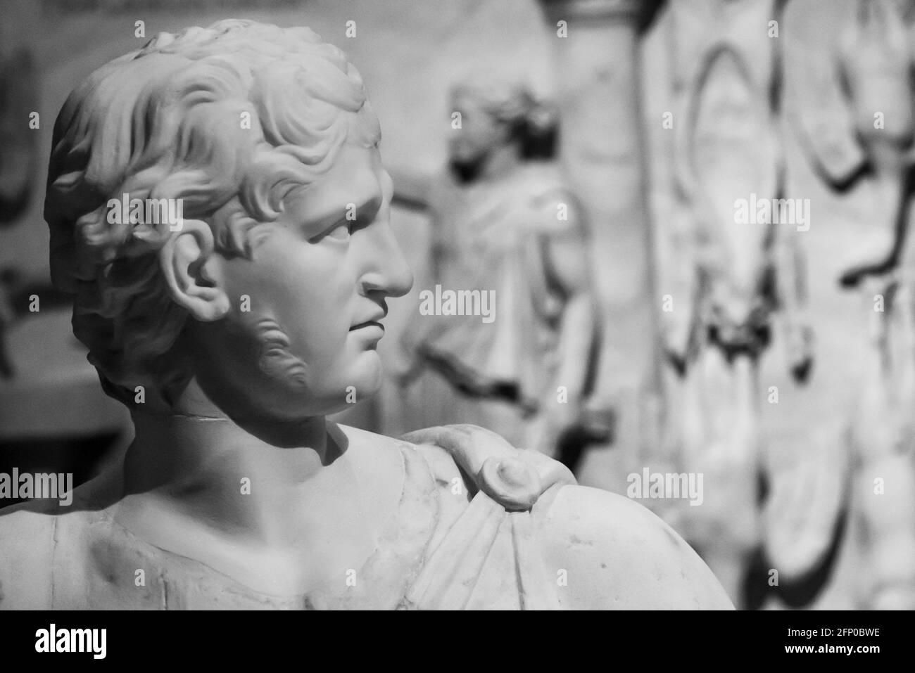 Black and white photo of ancient roman statue in close-up showing the handsome face of a young man in profile Stock Photo