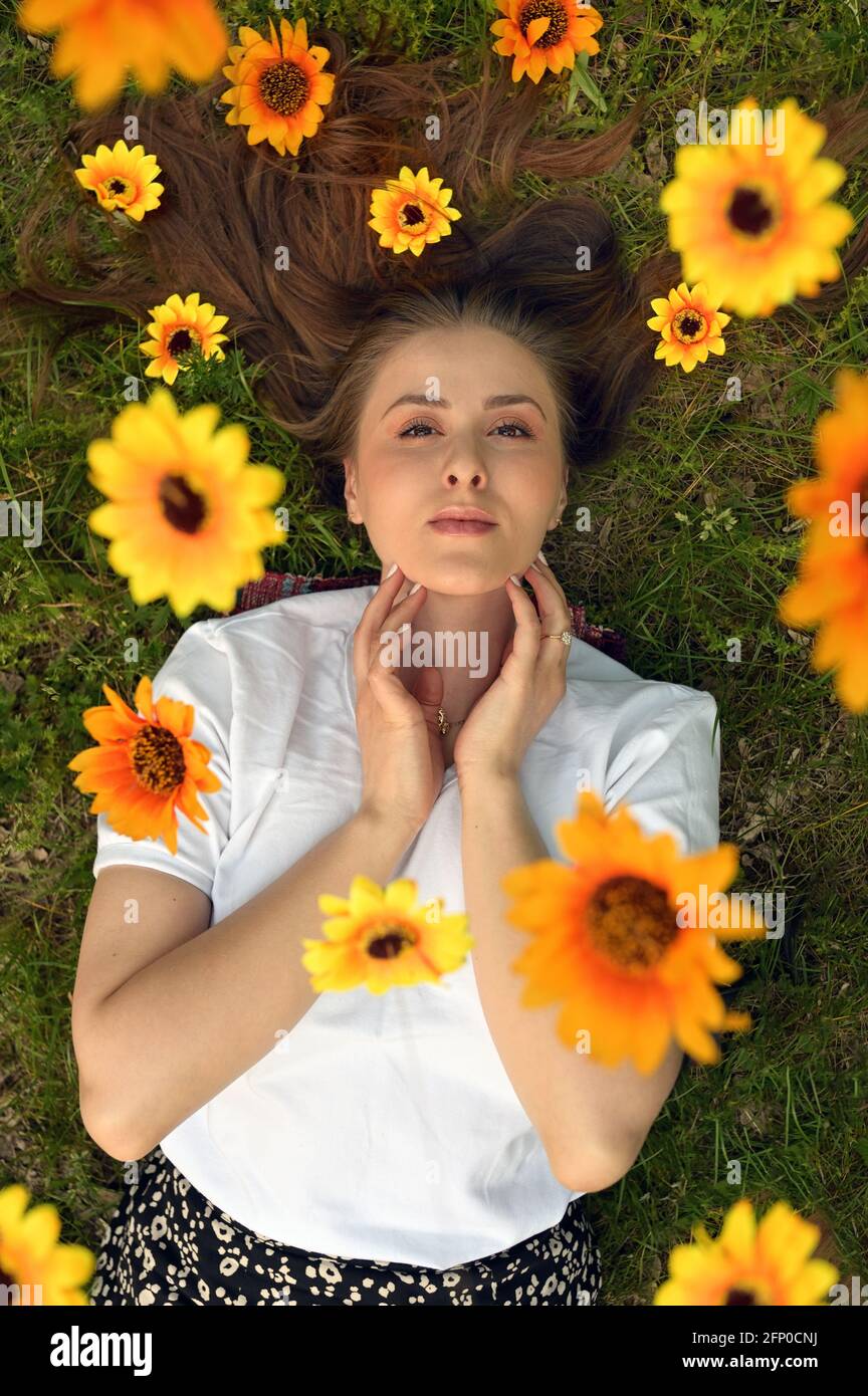 Portrait Of A Happy Fresh Girl With Flowers In Her Hair on Field Stock