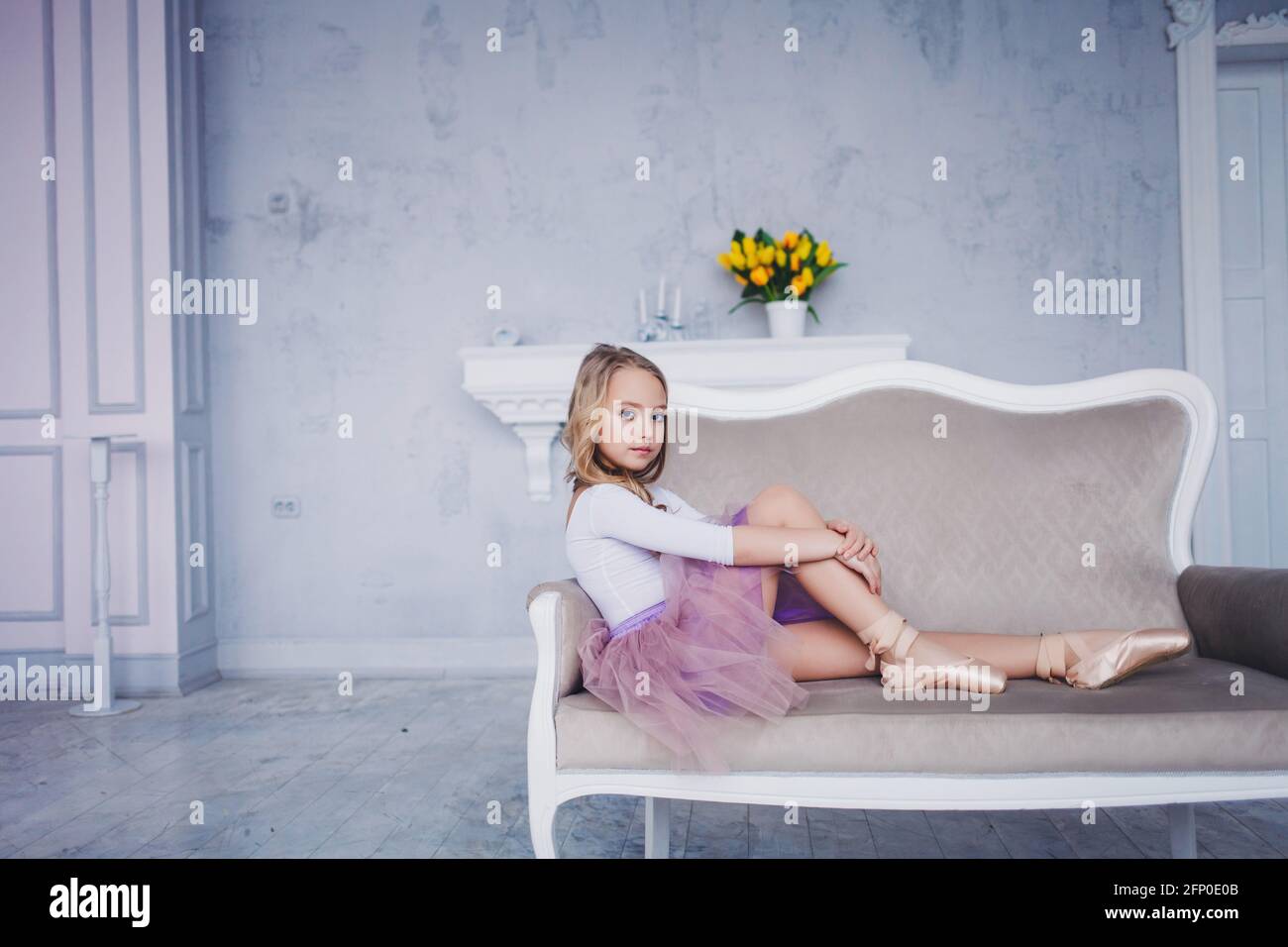 fashionable little girl in a dress lying on the couch and resting Stock ...