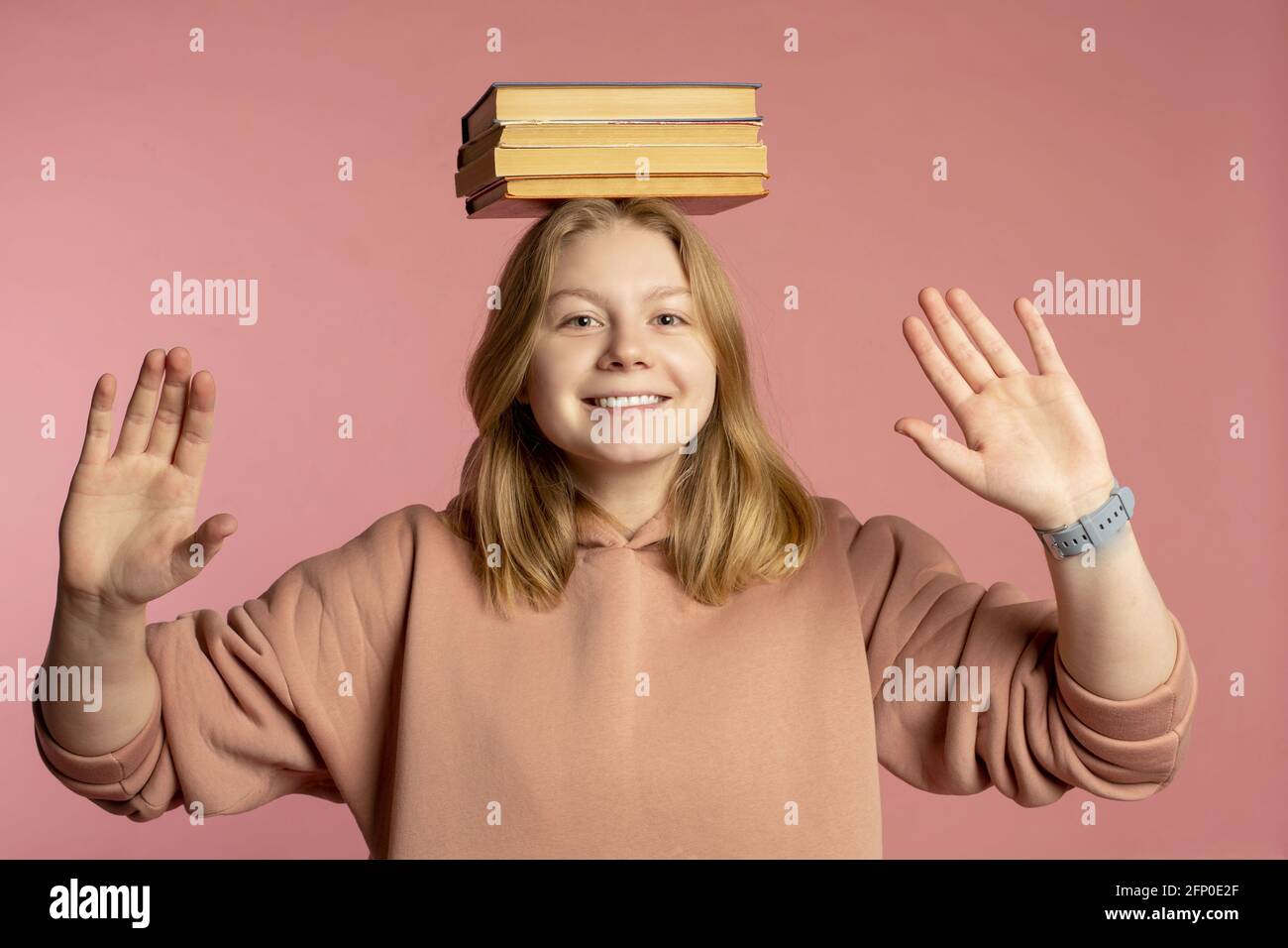 Happy girl student balancing stack of books on head Stock Photo - Alamy