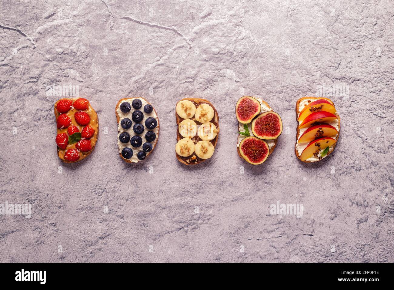 Homemade summer toast with cream cheese, nut butter and fruits and