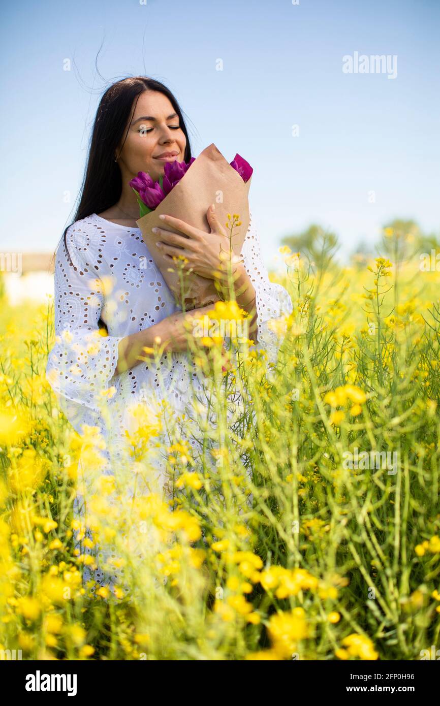 Pretty young woman in the rapeseed field Stock Photo - Alamy