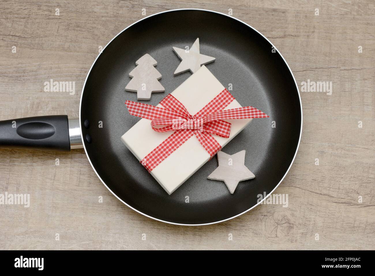 frying pan and present on wooden table Stock Photo
