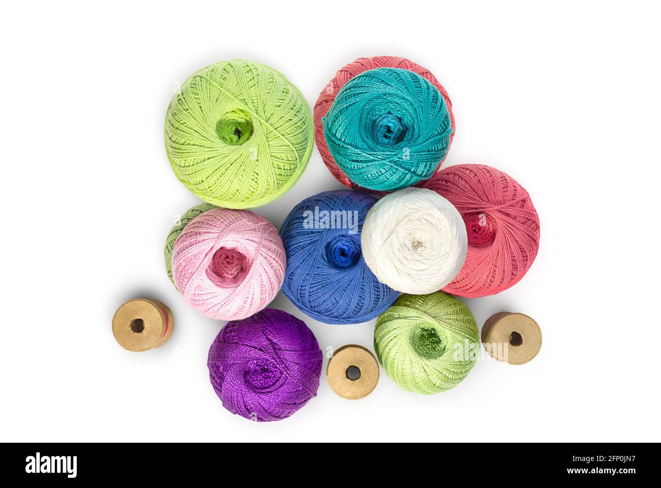 Multicolored balls and bobbins of woolen yarn, wooden thread sleeves on white isolated background. Needlework, handmade. view from above. Isolated. Co Stock Photo