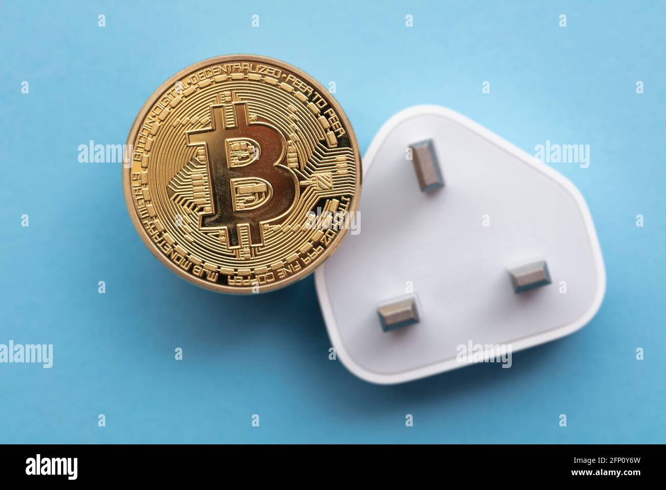 bitcoin cryptocurrency energy consumption concept. Gold coin with electric plug Stock Photo