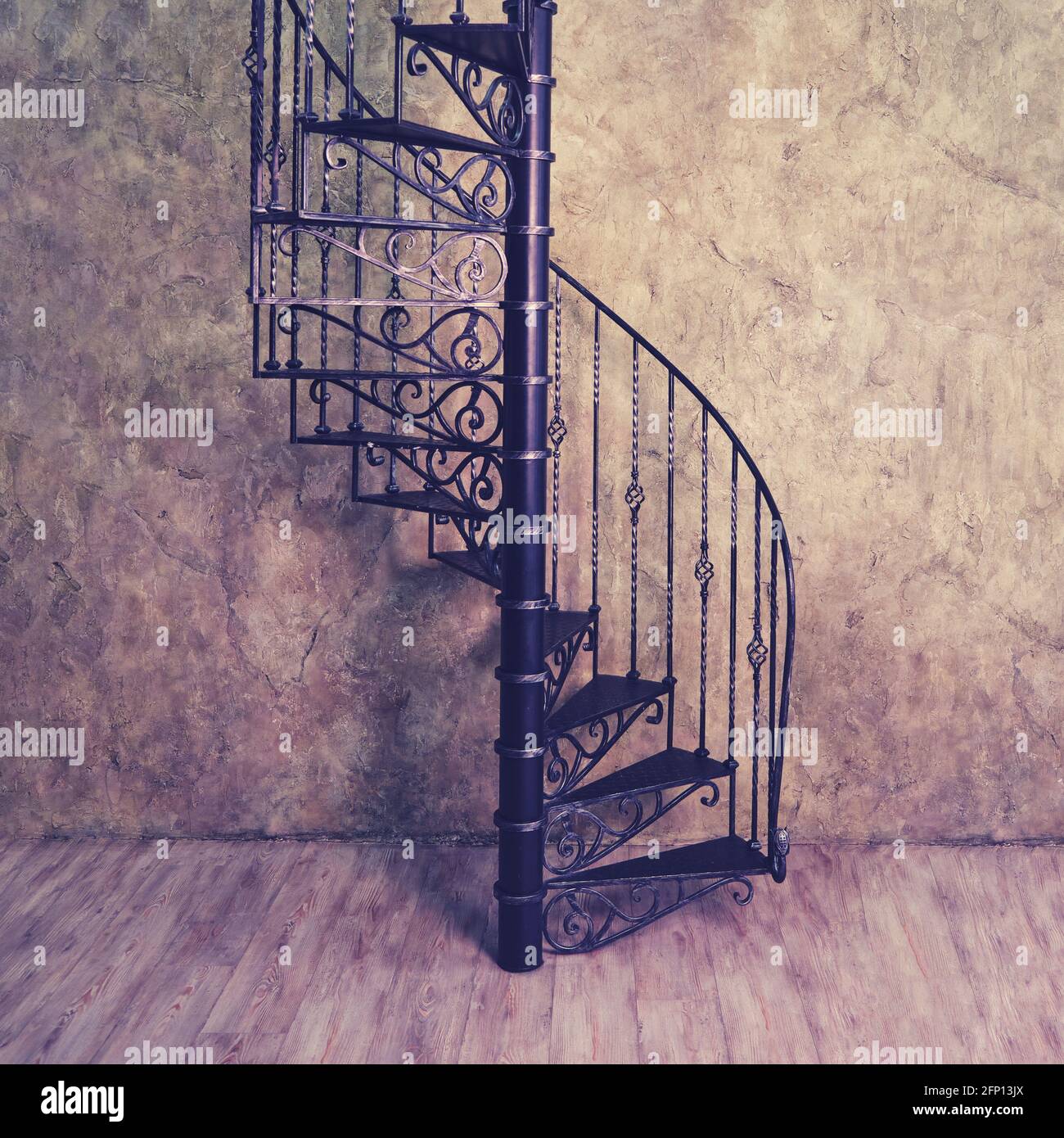 Retro cast iron spiral staircase on the background of an old wall and