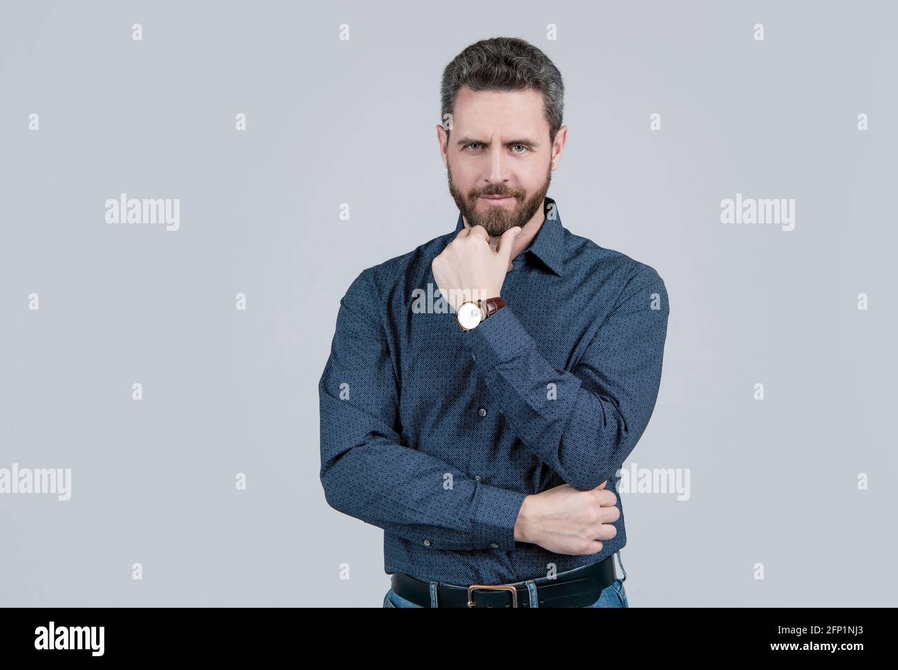 Middle-aged unshaven man with serious look touch beard hair in casual fashion style, bearded. Stock Photo