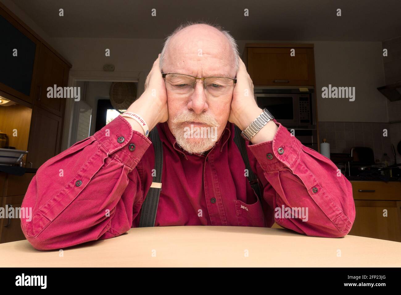 Man with hands covering his ears, unwilling to listen or hear Stock Photo