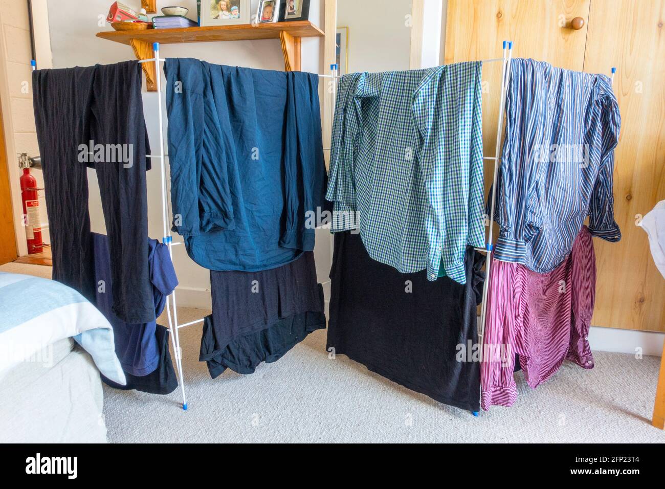 Clothes on a drying rack in a bedroom Stock Photo
