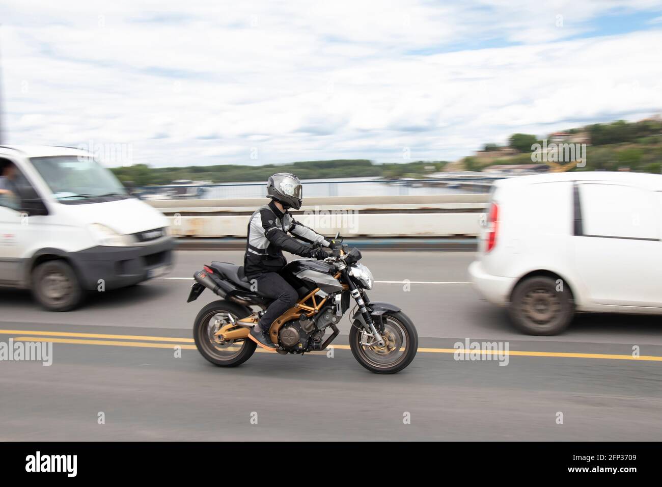 Belgrade, Serbia - May 14, 2021: One man riding a motorbike in traffic, over the city bridge Stock Photo
