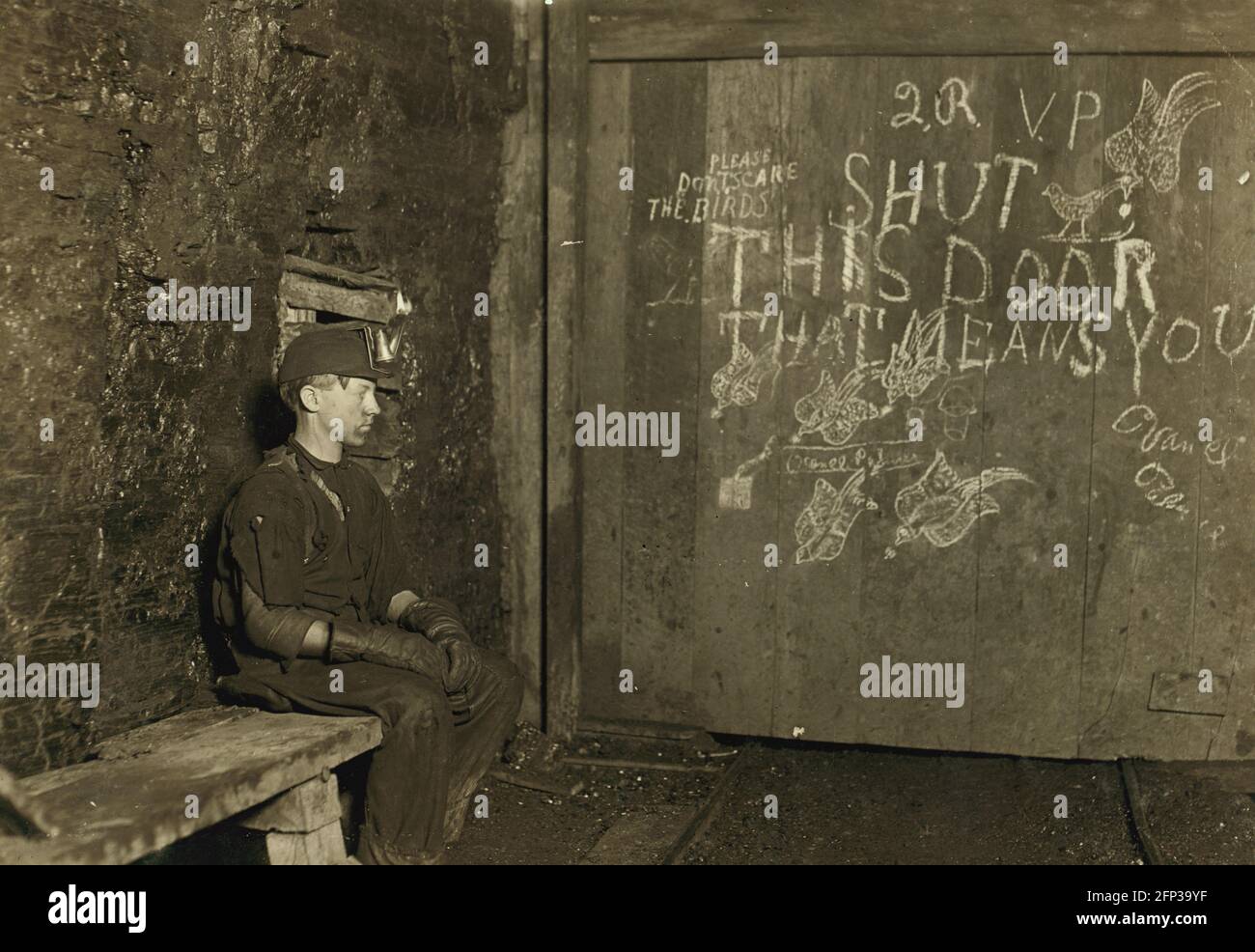 Child Labour: a 15 year old boy waiting to open the door deep in a coal mine in West Virginia. He was paid 75c for a 10 hour day. Photo 1908 Stock Photo