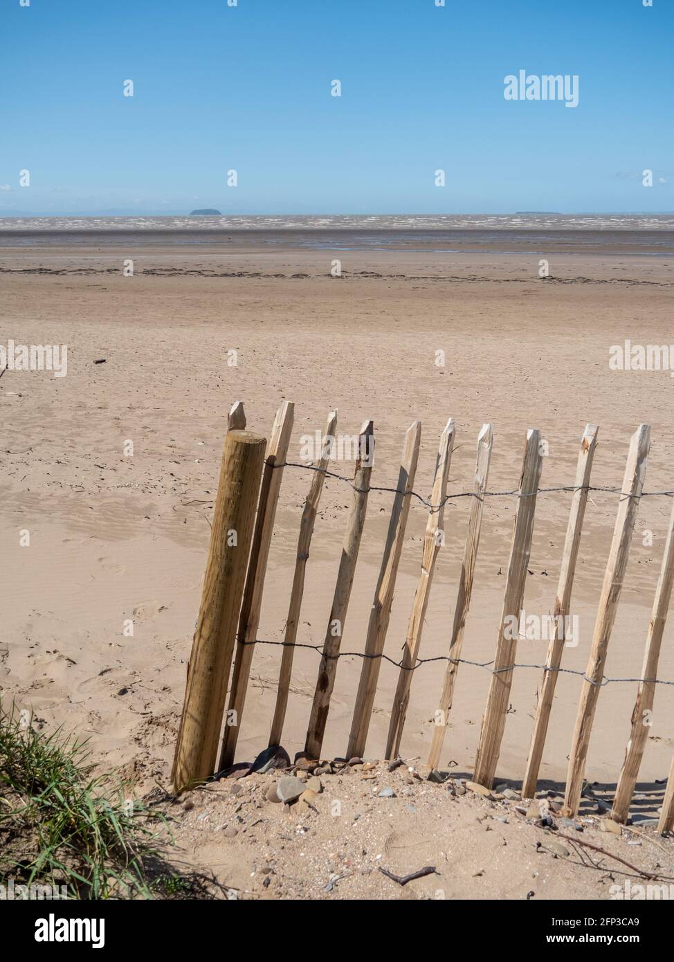 A beach fence at Sand Bay, near Weston-super-Mare, looking out towards the Bristol Channel and Steepholm Island. Stock Photo