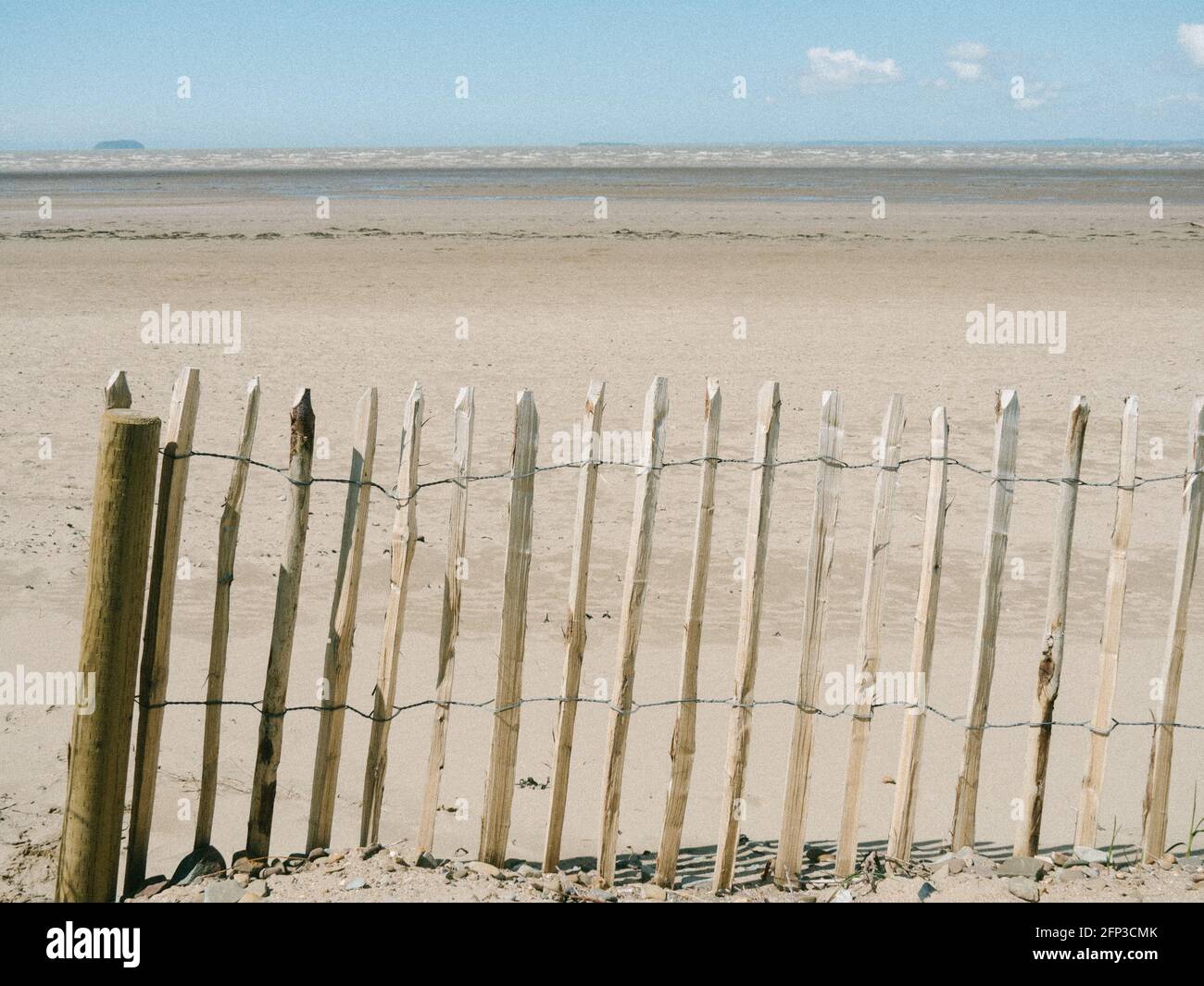 A beach fence at Sand Bay, near Weston-super-Mare, looking out towards the Bristol Channel and Steepholm Island. Stock Photo