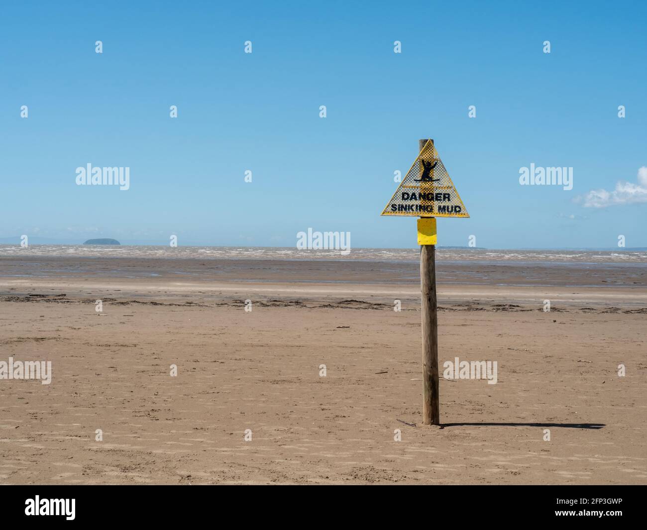 A warning sign about the danger of sinking mud at low tide, in Sand Bay, near Weston-super-Mare, in North Somerset. Stock Photo