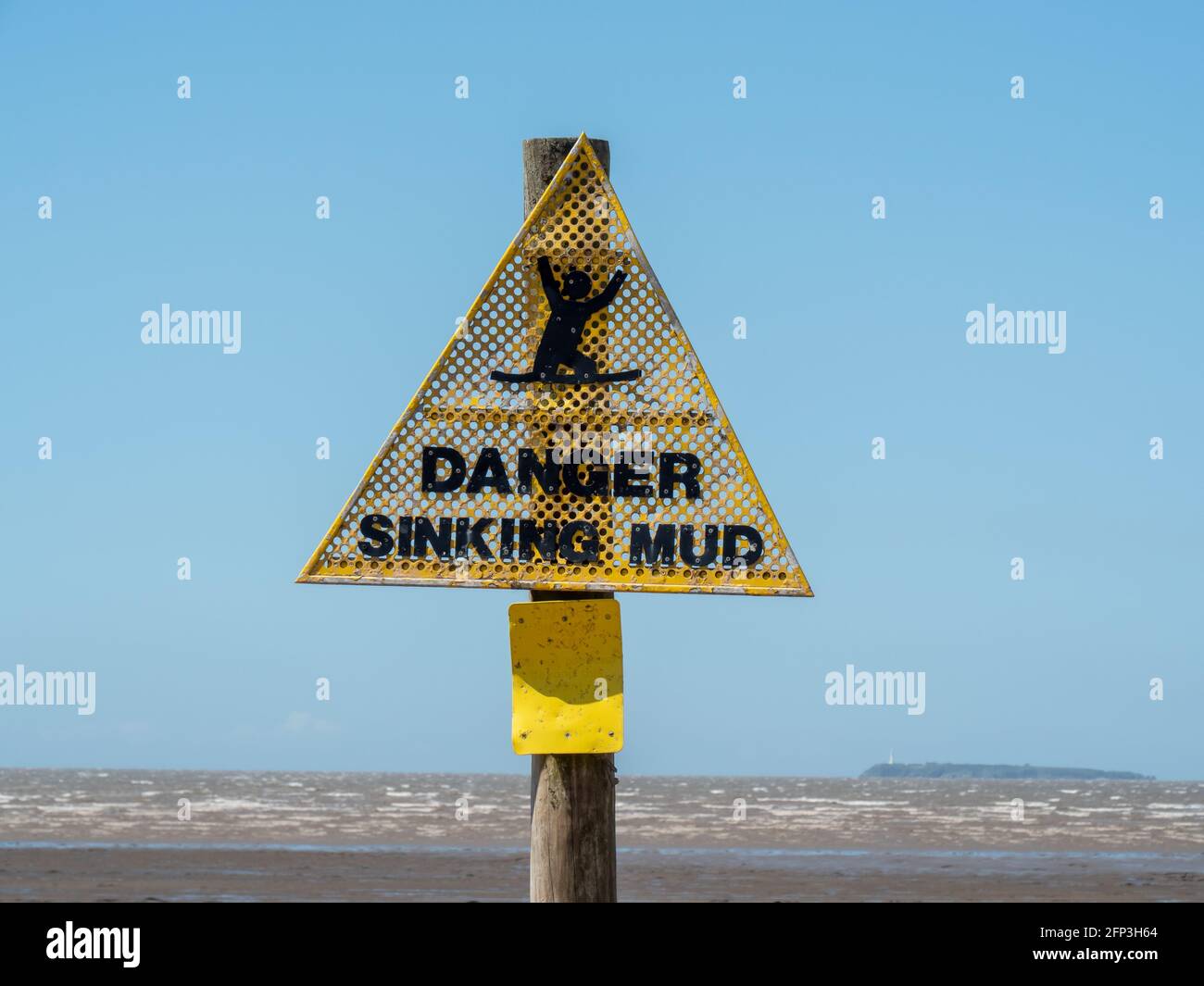 A warning sign about the danger of sinking mud, at low tide, on Sand Bay beach, near Weston-super-Mare, in North Somerset Stock Photo