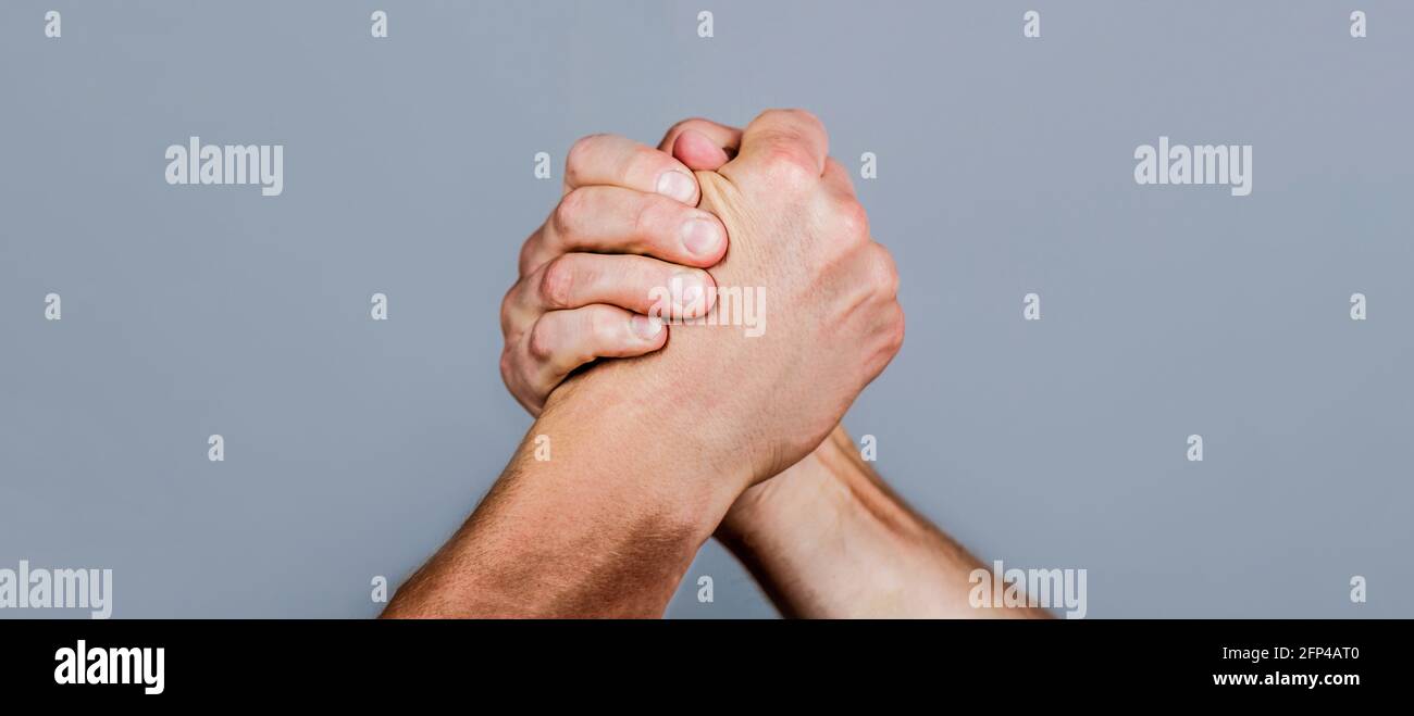 Two men arm wrestling. Arms wrestling. Closep up. Friendly handshake, friends greeting, teamwork