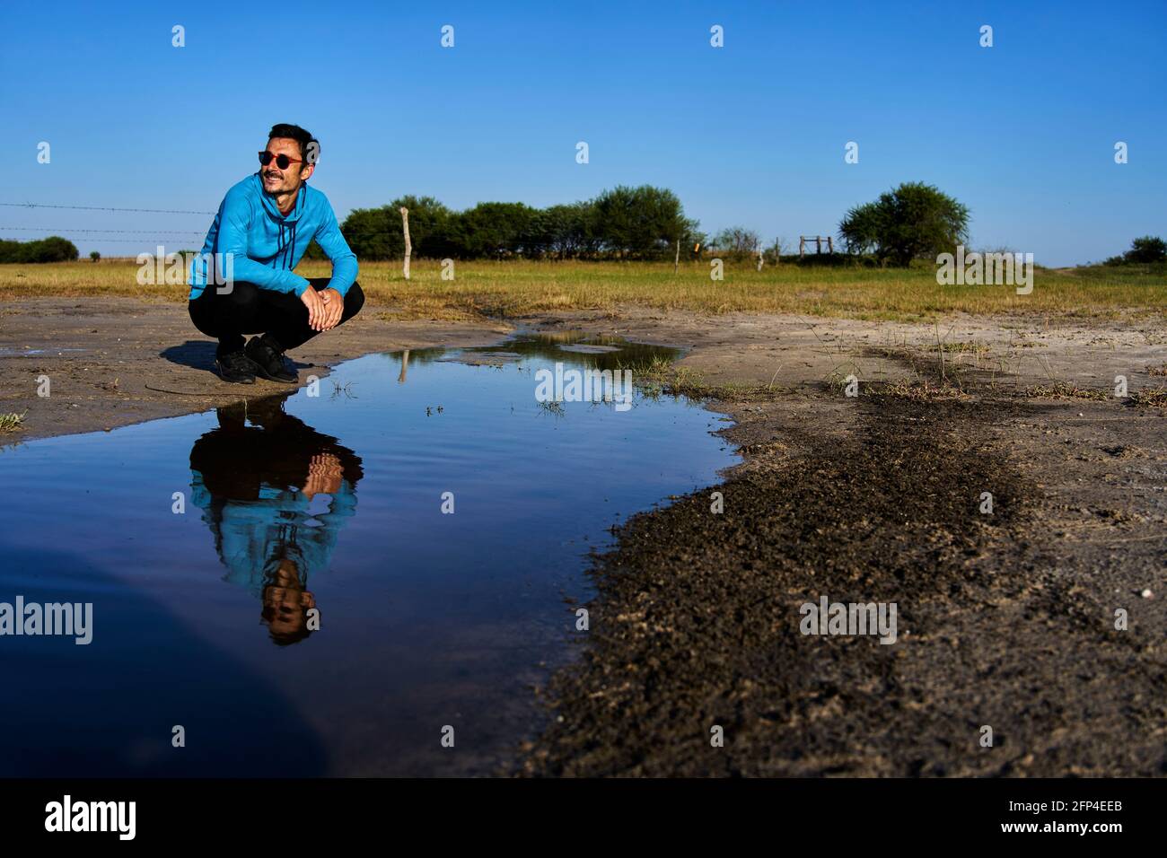 Young man smiling reflected in water Stock Photo