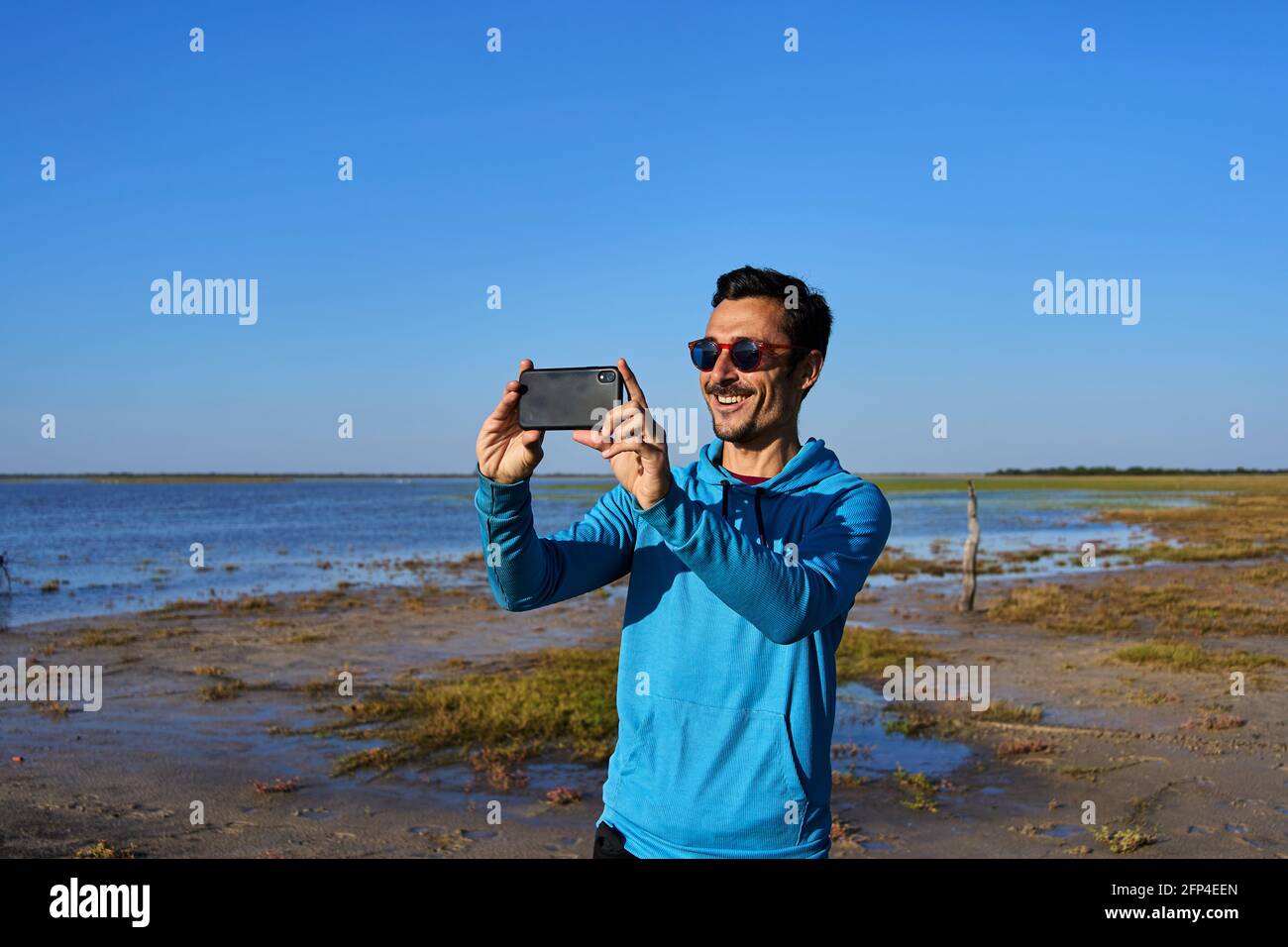 Young man smiling while taking a picture Stock Photo