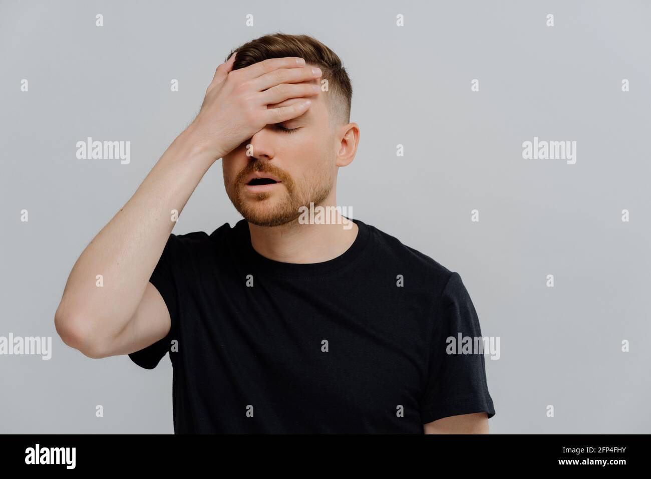 Depressed man doing facepalm gesture and being disappointed Stock Photo