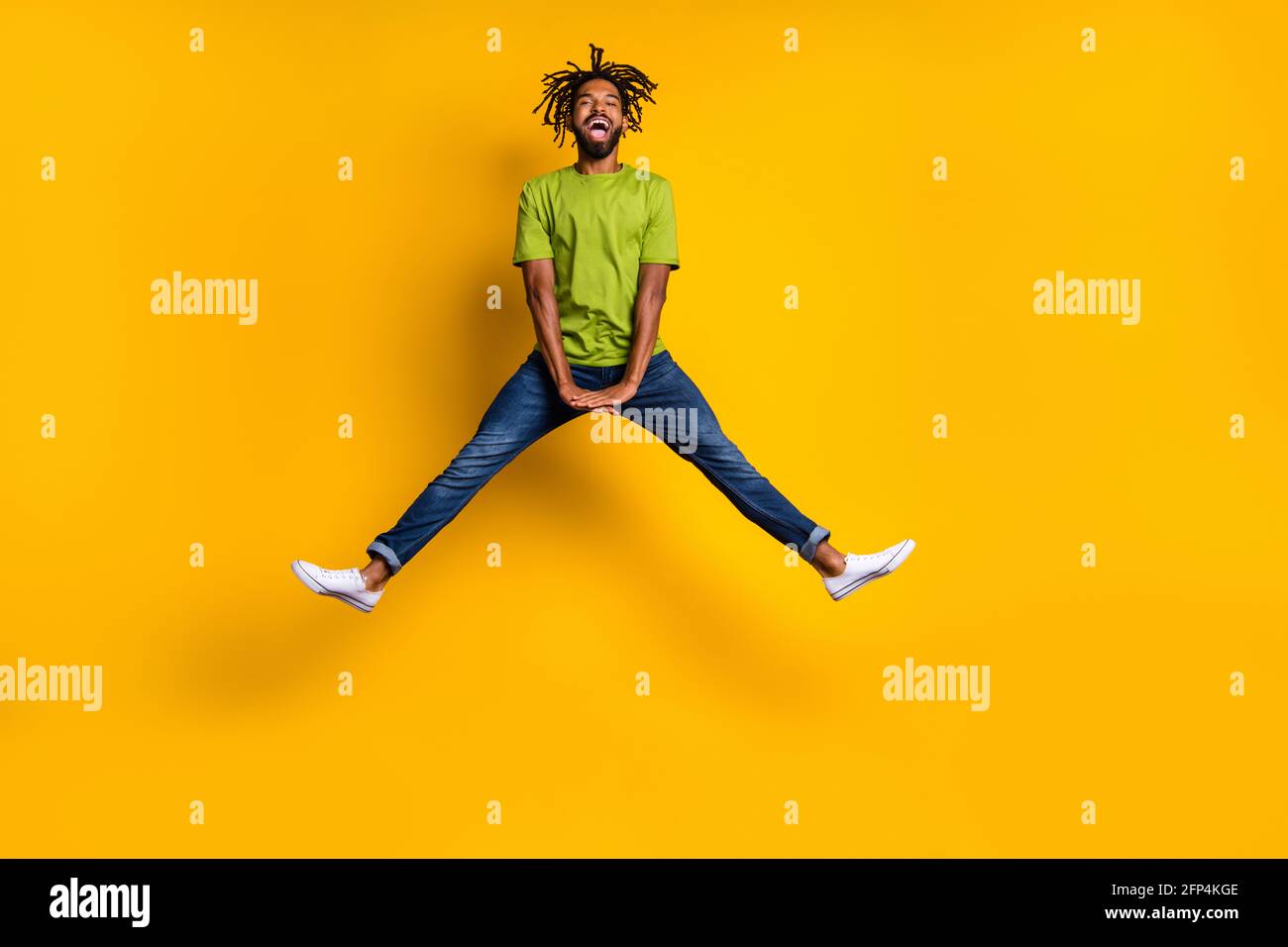 Full length photo portrait of guy jumping up spreading legs isolated on ...