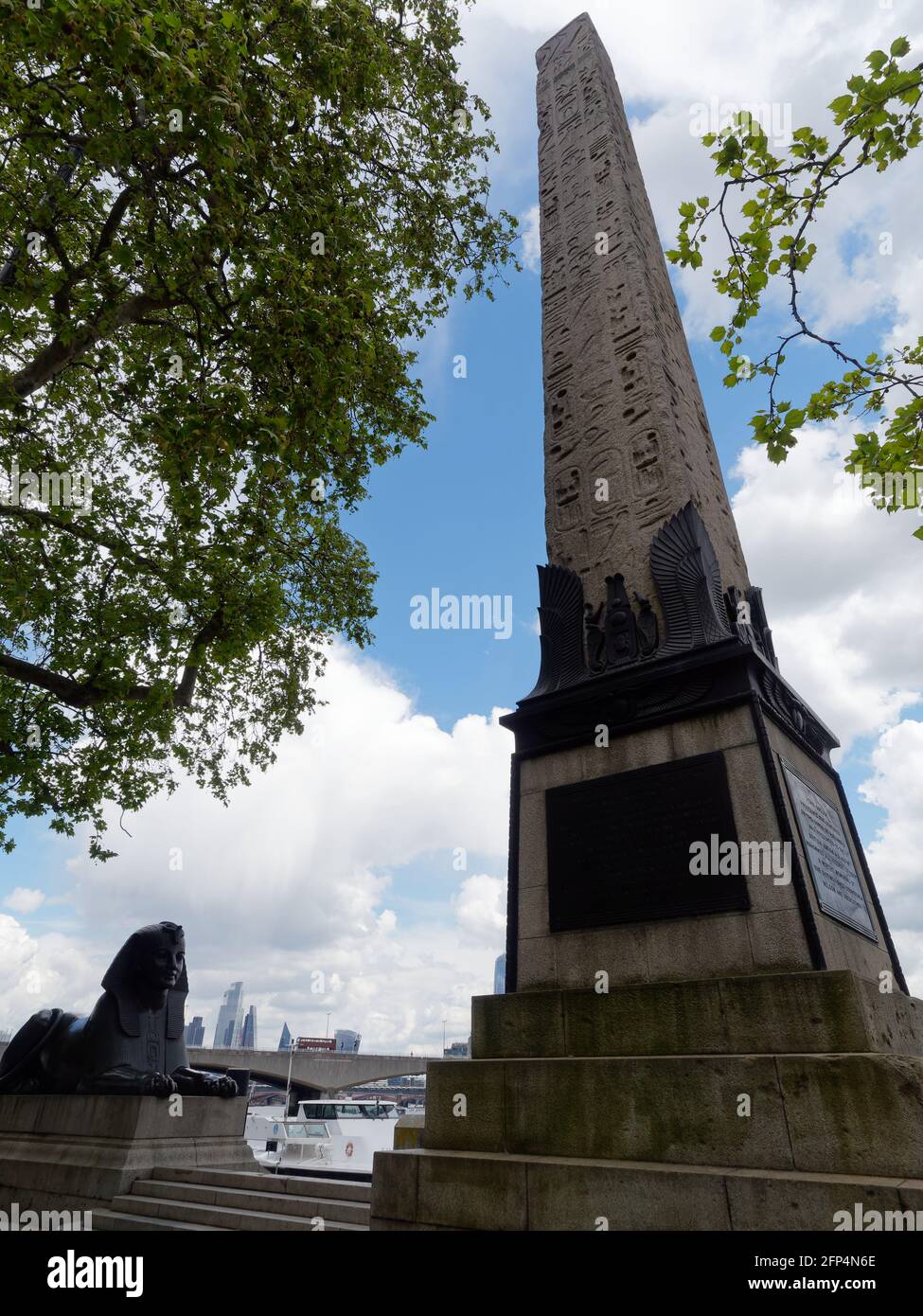 London, Greater London, England - May 18 2021: Cleopatras Needle an Eqyption Obelisk and a bronze Spinx statue near Embankment Gardens. Stock Photo