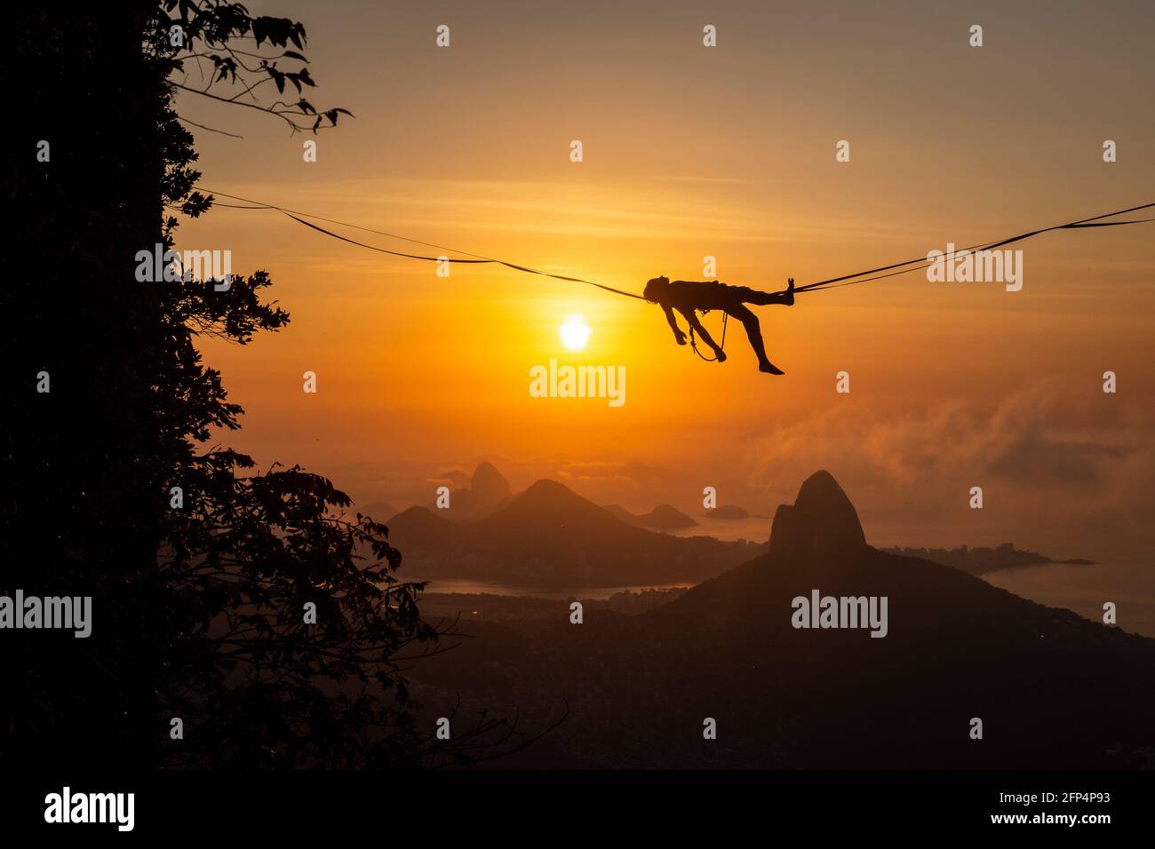 Beautiful view to male highliner silhouette laying down on mountain