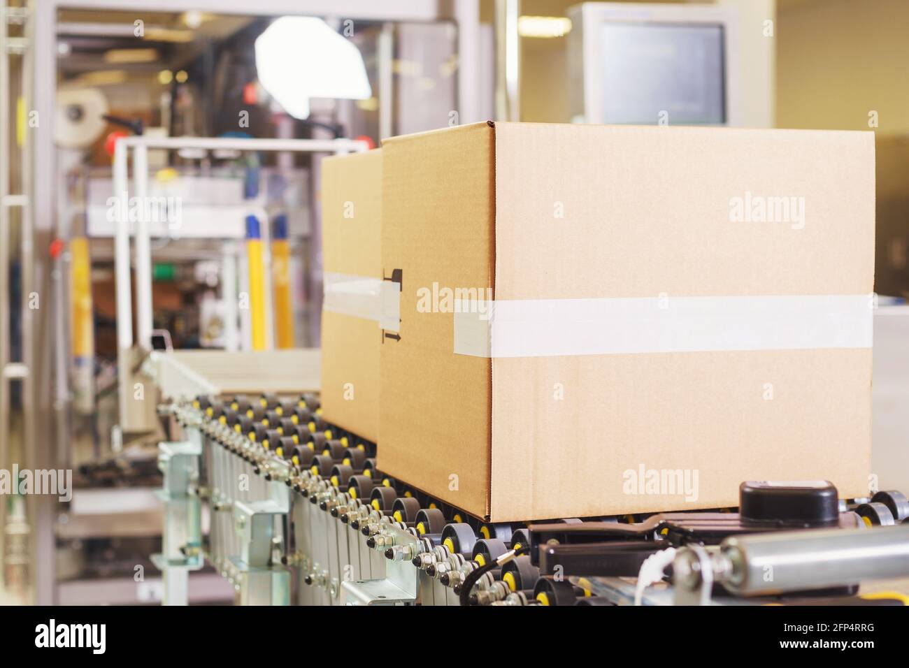 Sealed cardboard box on a conveyor belt in a factory Stock Photo