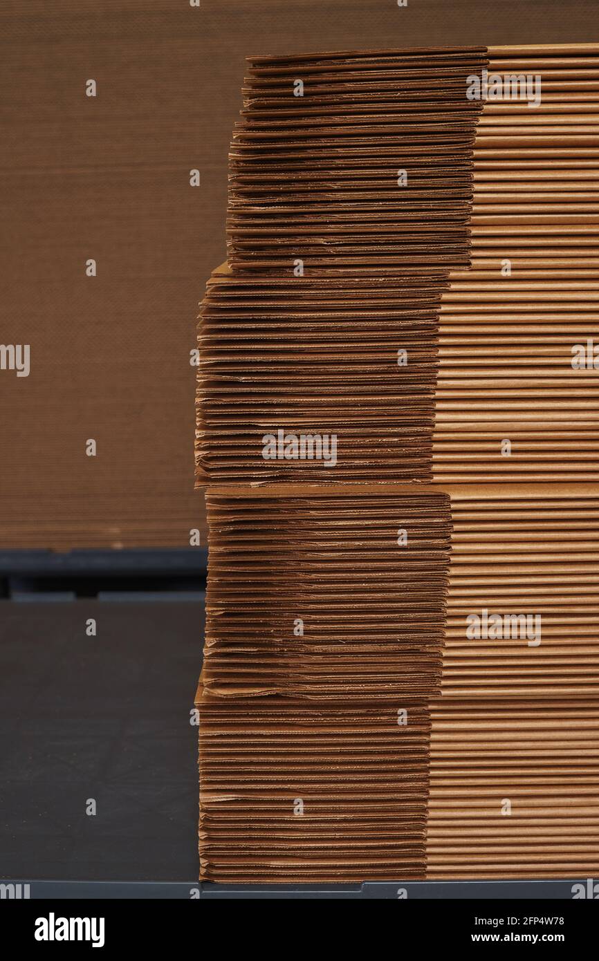 Stack of cardboard packaging folded in sheets in a factory. Stock Photo