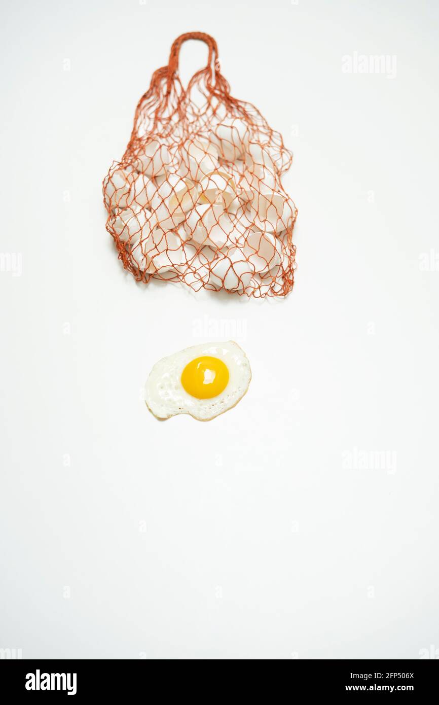 scrambled eggs with whole yolk and broken shells in net bag Stock Photo