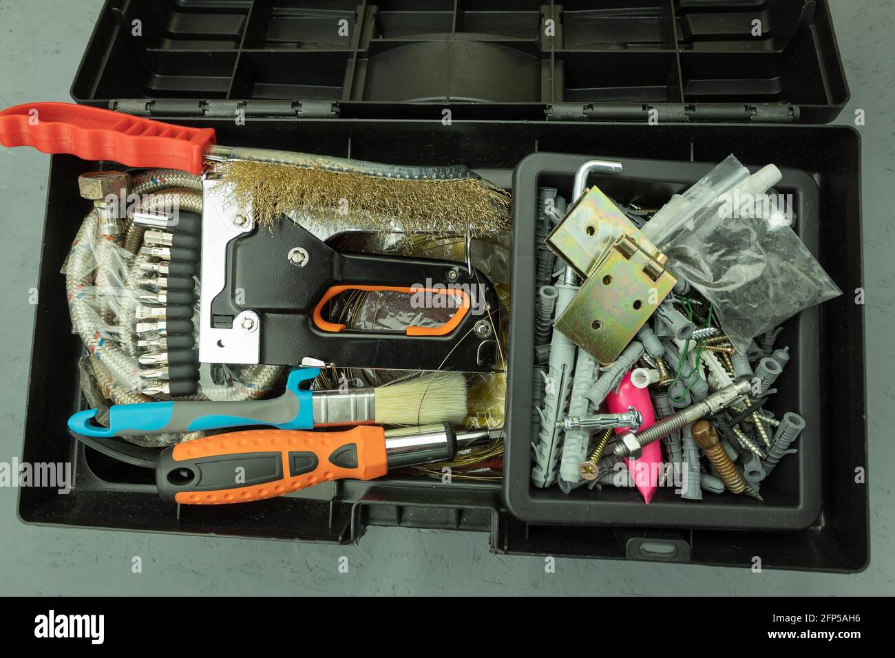 Open large black box for construction tools. Carrying case with many tools on gray background Stock Photo