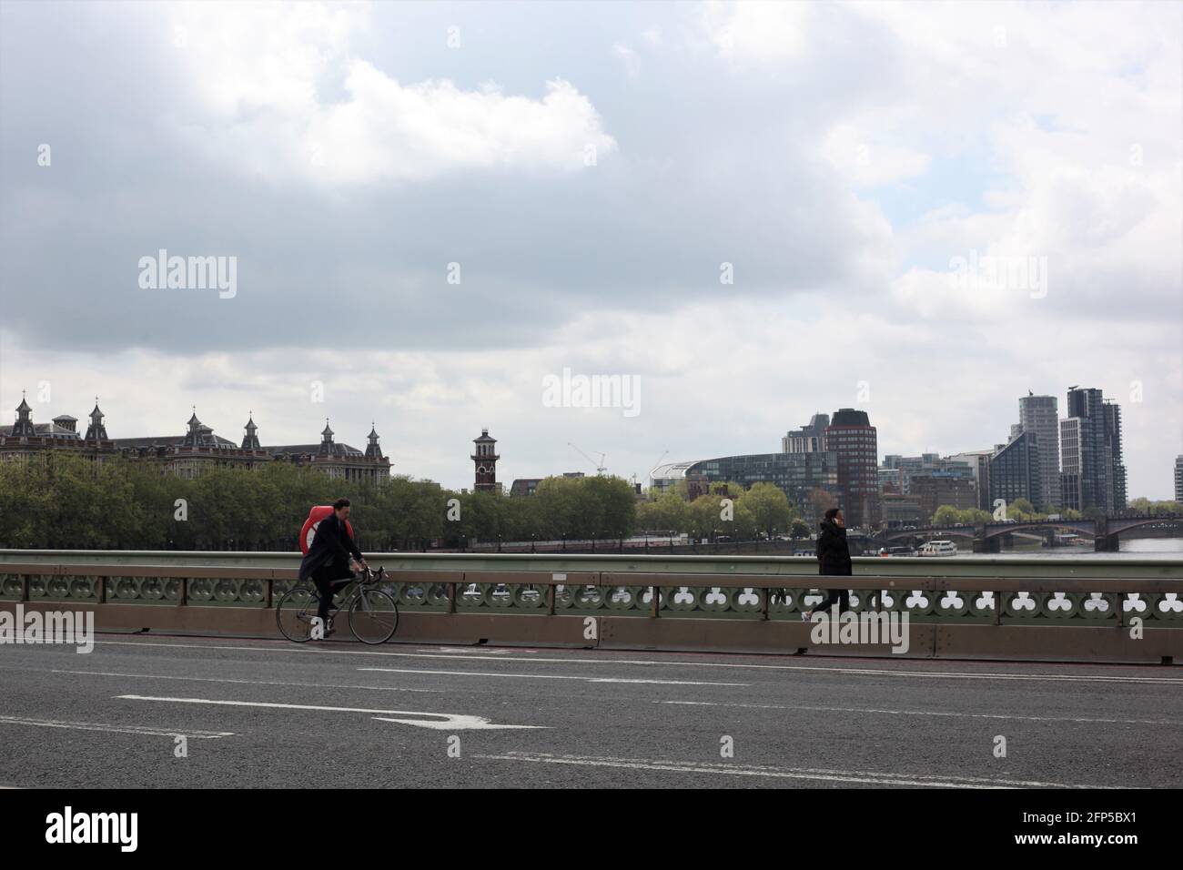 Cyclist and pedestrian crossing Westminster Bridge , London, Britain, May 2021 Stock Photo