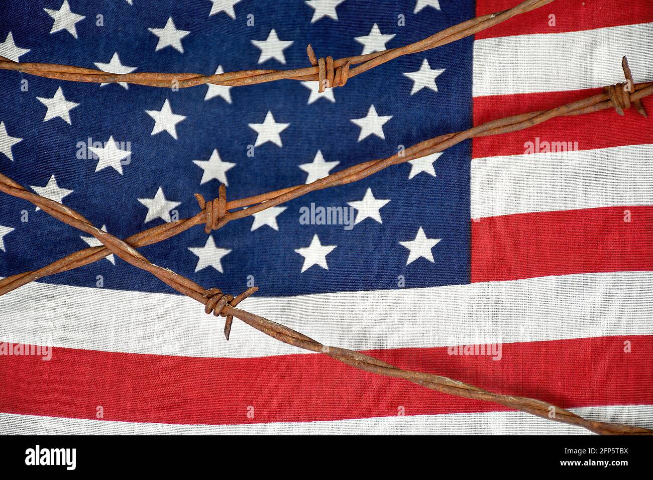 close up of rusty barbed wire fencing on American flag Stock Photo