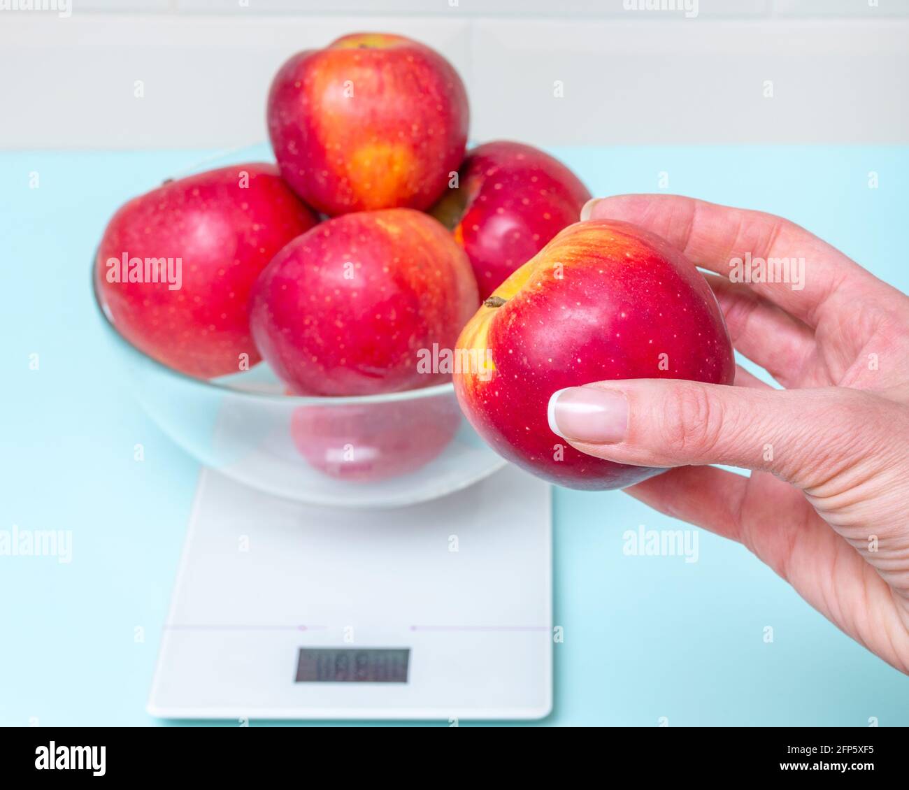 three apples lying on weight scale Stock Photo - Alamy
