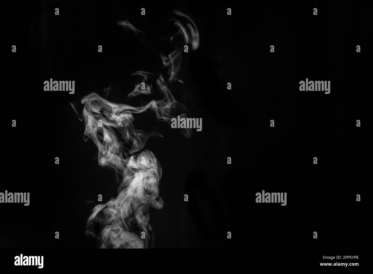 Perfect mystical curly white steam or smoke isolated on black background. Abstract background fog or smog, design element for Halloween, layout for co Stock Photo