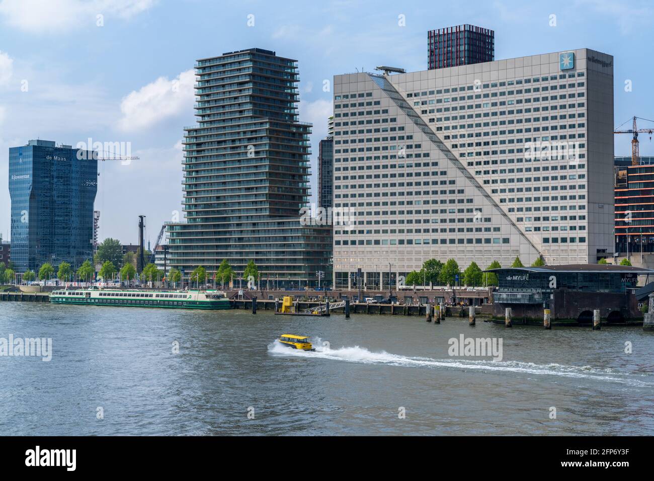 Rotterdam, Netherlands - 14 May, 2021: yellow water taxi on the Nieuwe Maas River with downtown Rotterdam skyscrapers behind Stock Photo