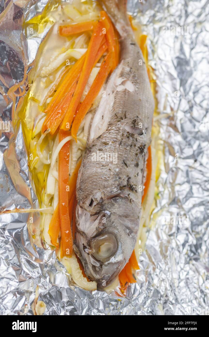 Vertical top shot of baked fish with fresh vegetable en papillote style