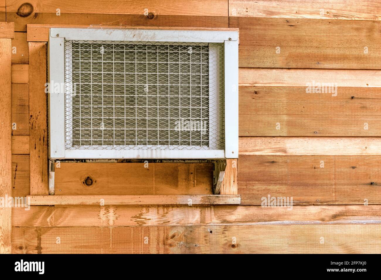 Horizontal shot of a window air conditioner unit in a wooden wall with copy space. Stock Photo