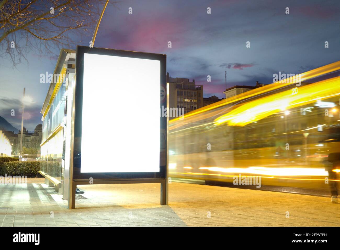 Blank advertisement mock up in a bus stop, with blurred traffic lights at night Stock Photo