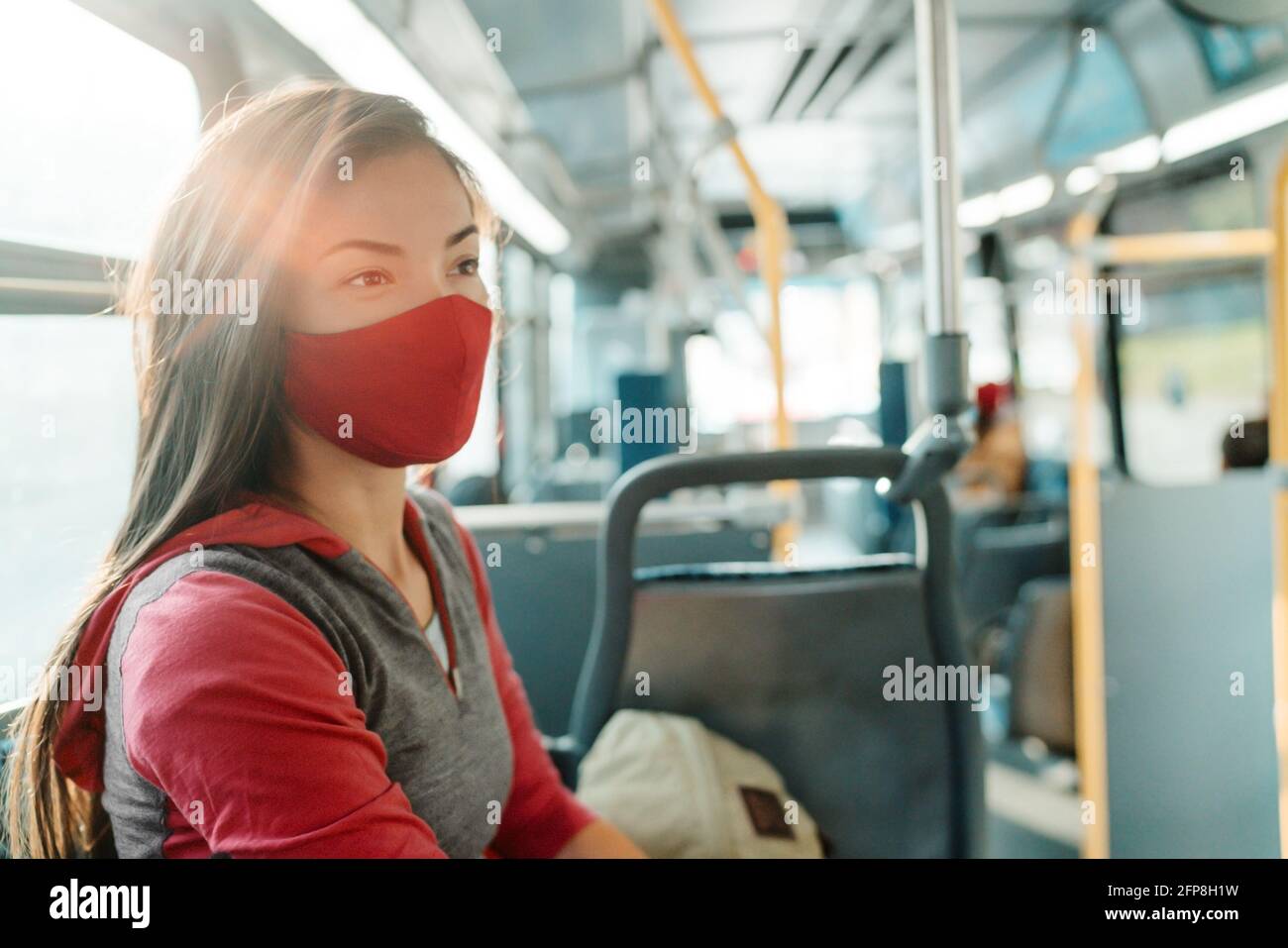 Woman wearing face mask inside public transport bus commuting to work