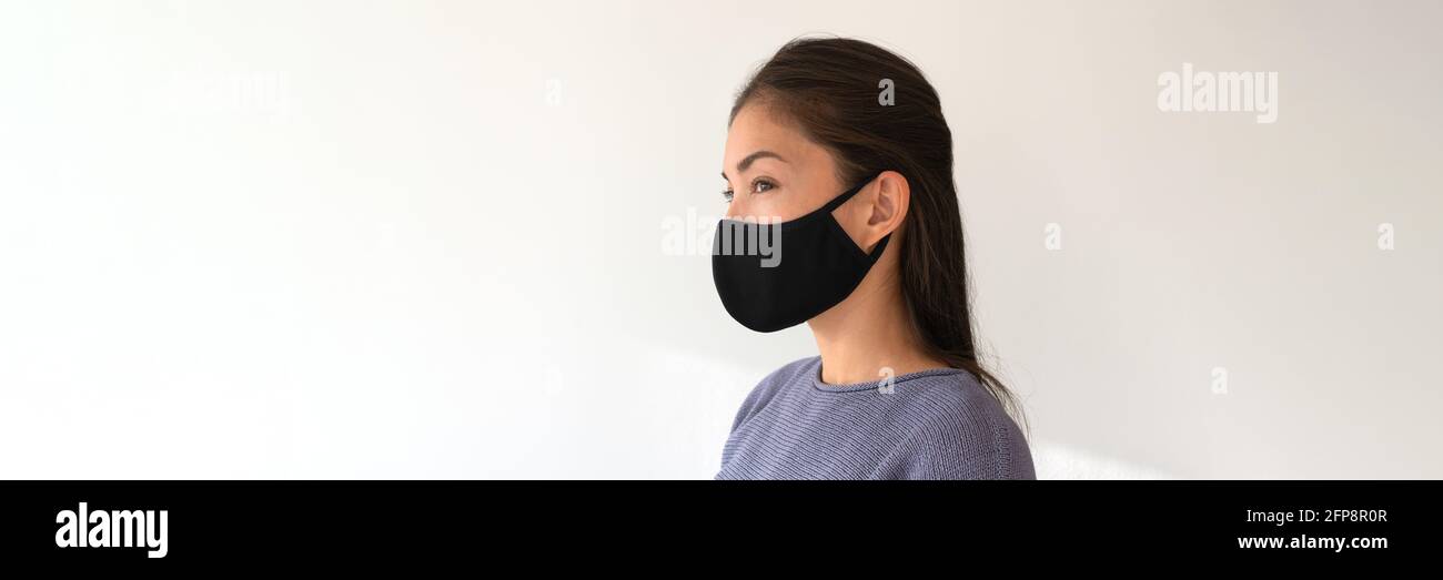 Asian woman wearing black fabric face mask. Casual lifestyle of young people during coronavirus pandemic. Portrait of ethnic girl model with Stock Photo